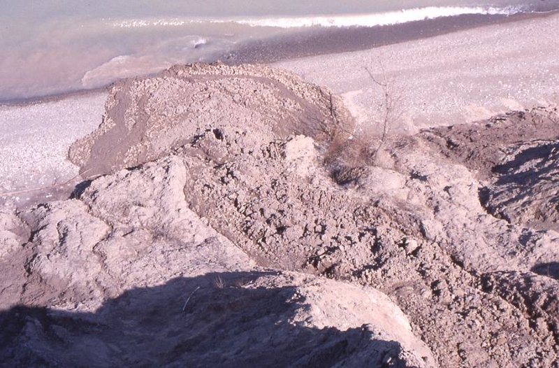 Soil becomes saturated with water and flows down the bluff similar to a mud slide.